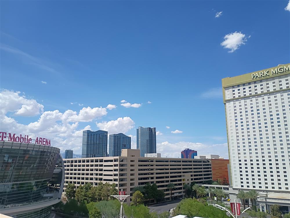 A wide-angle shot of glass towers converging toward the sun
