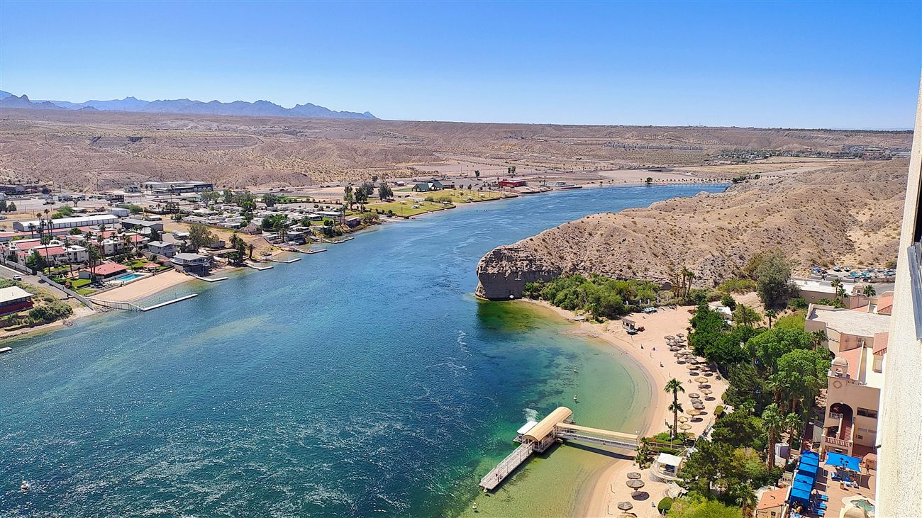 Aerial view of the Colorado River bend with a beach and umbrellas in Laughlin