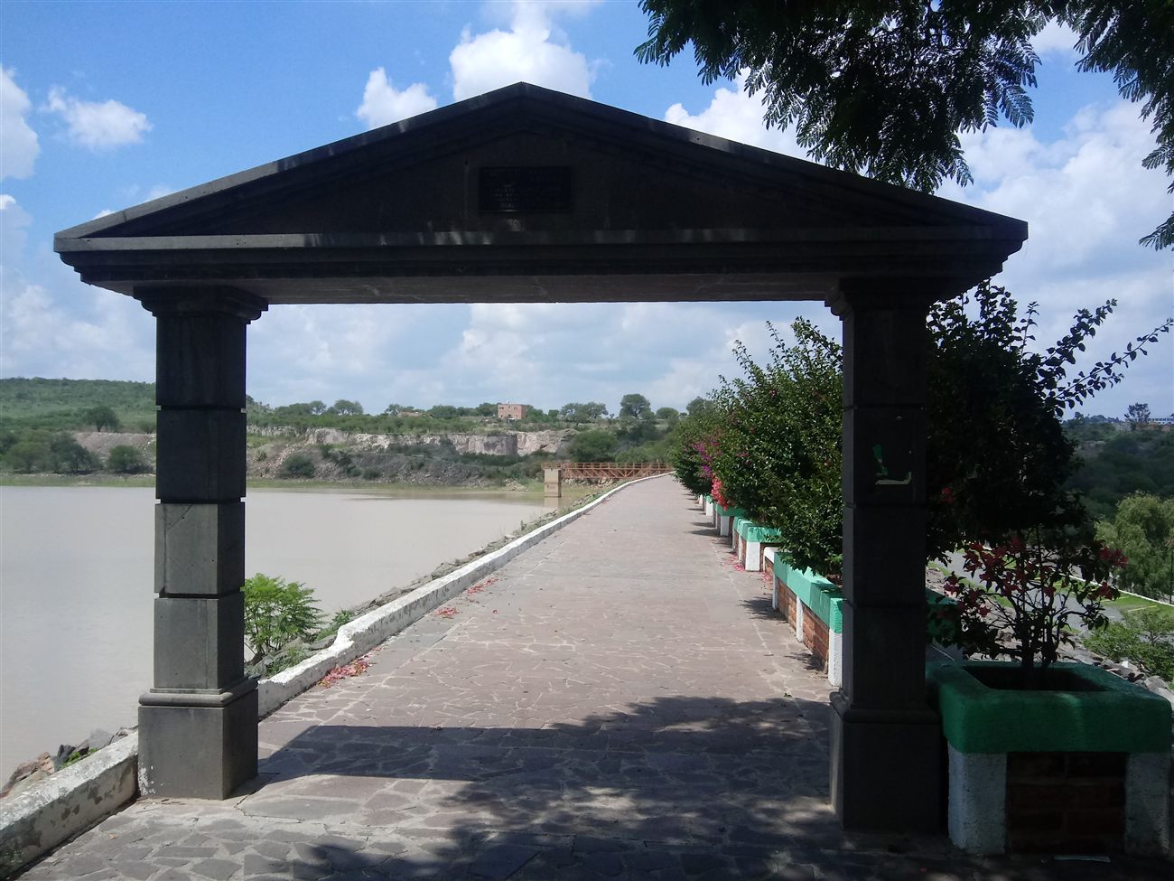A lakeside walkway with a stone archway