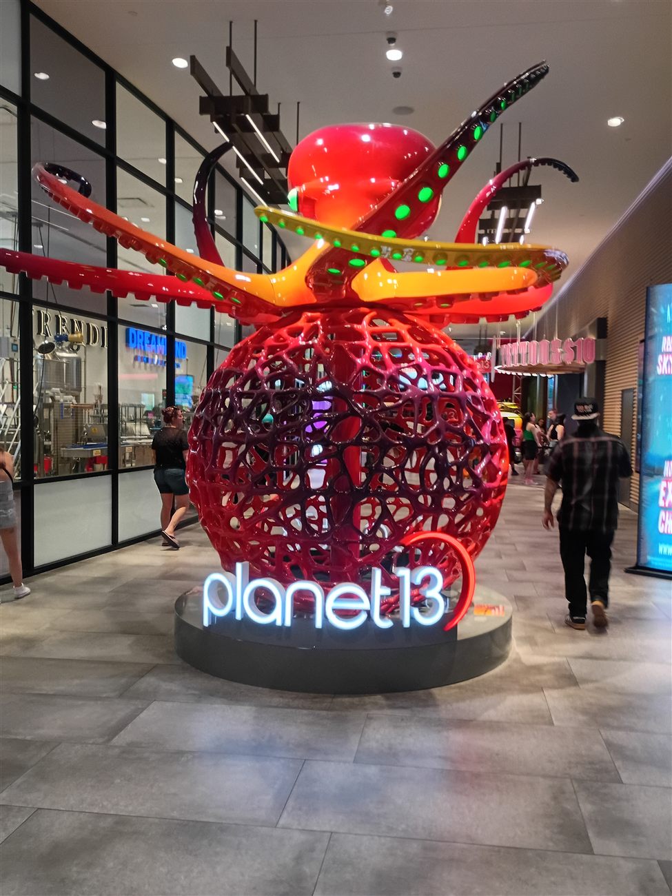 A giant red alien octopus sculpture above the Planet 13 sign