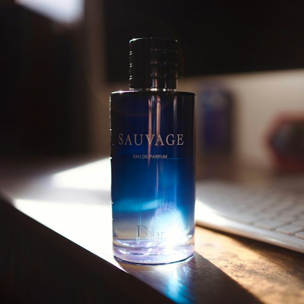 A bottle of Dior Sauvage Eau de Parfum lit by warm sunlight